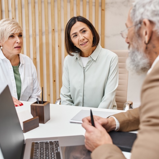 middle aged multicultural lgbt couple discussing property with bearded realtor in real estate office  | Will Writing Service Ealing